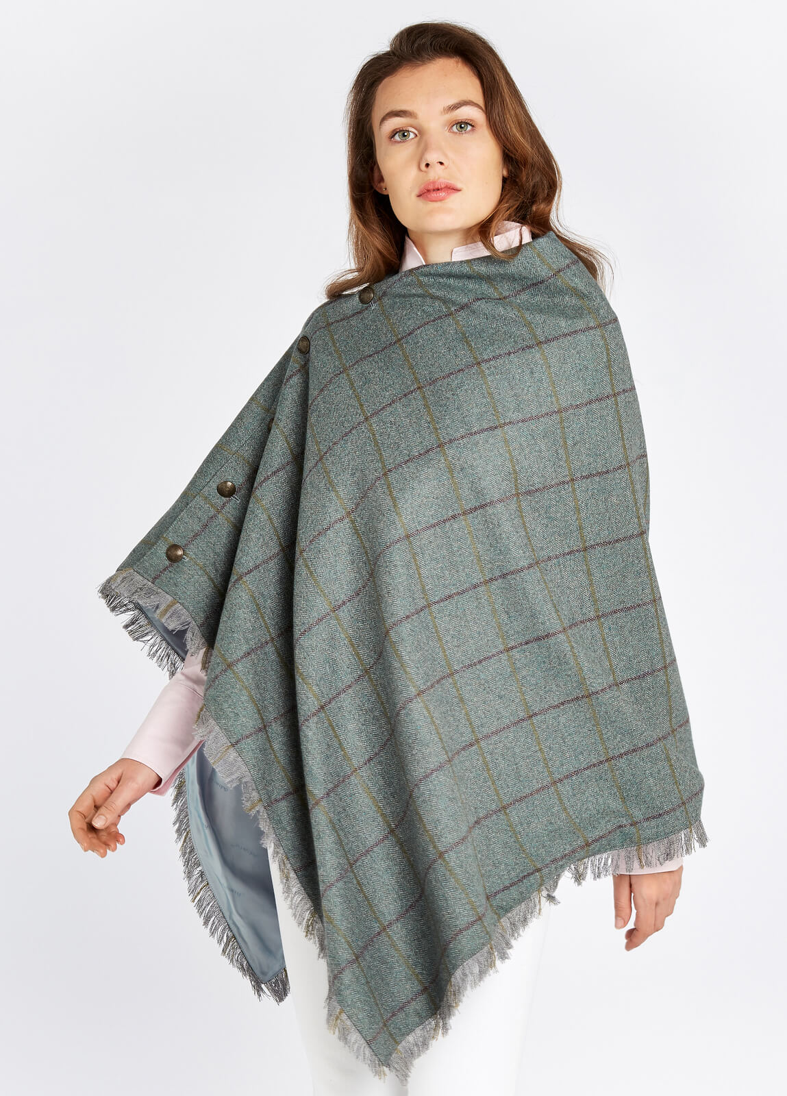 Woman modelling Dubarry Hazelwood Sorrel Poncho with smart brass coloured buttons and fabric fringe. 