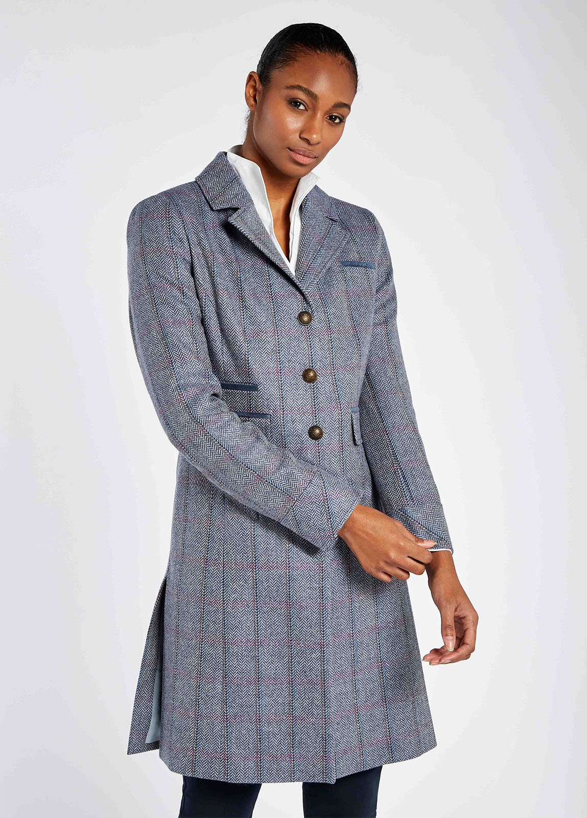 A woman modelling Dubarry women's Blackthorn Tweed Denim Haze Coat. A three-quarter-length tailored jacket with metal buttons and 100% wool.